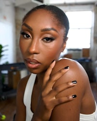 a black woman with black nails posing for a photo